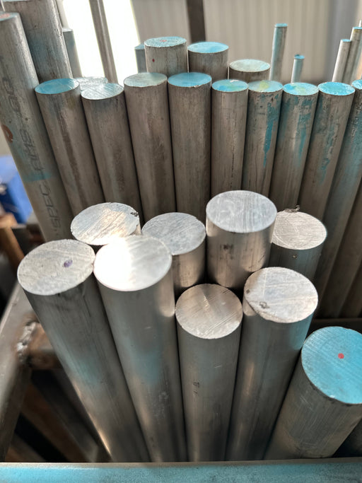 Varias barras de aluminio acomodadas en rack vistas desde abajo. Algunas pintadas de azul claro.