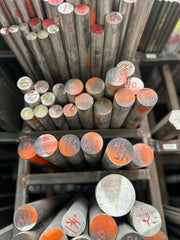 Barras de acero inoxidable 420 pintadas de negro con naranja colocadas en rack.