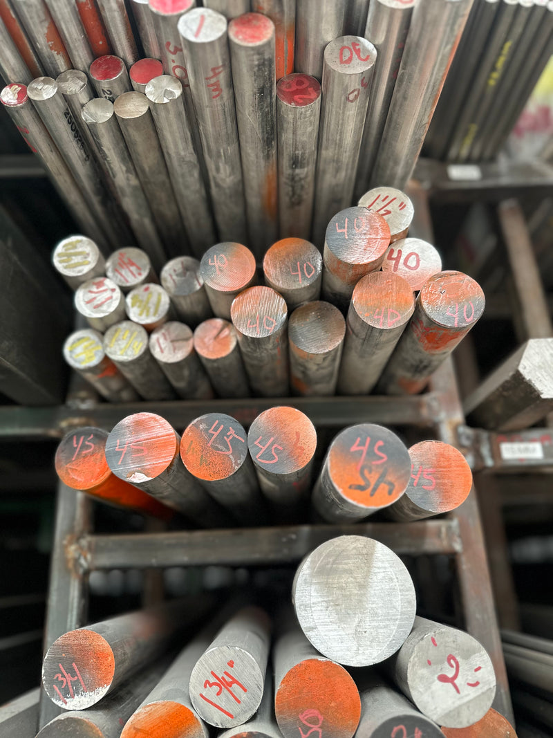 Barras de acero inoxidable 420 pintadas de negro con naranja colocadas en rack.