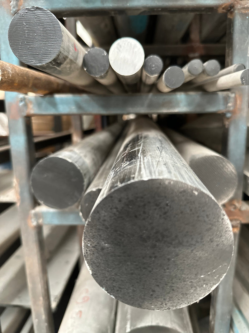 Barras de aluminio 7075 pintadas de negro colocadas en rack.