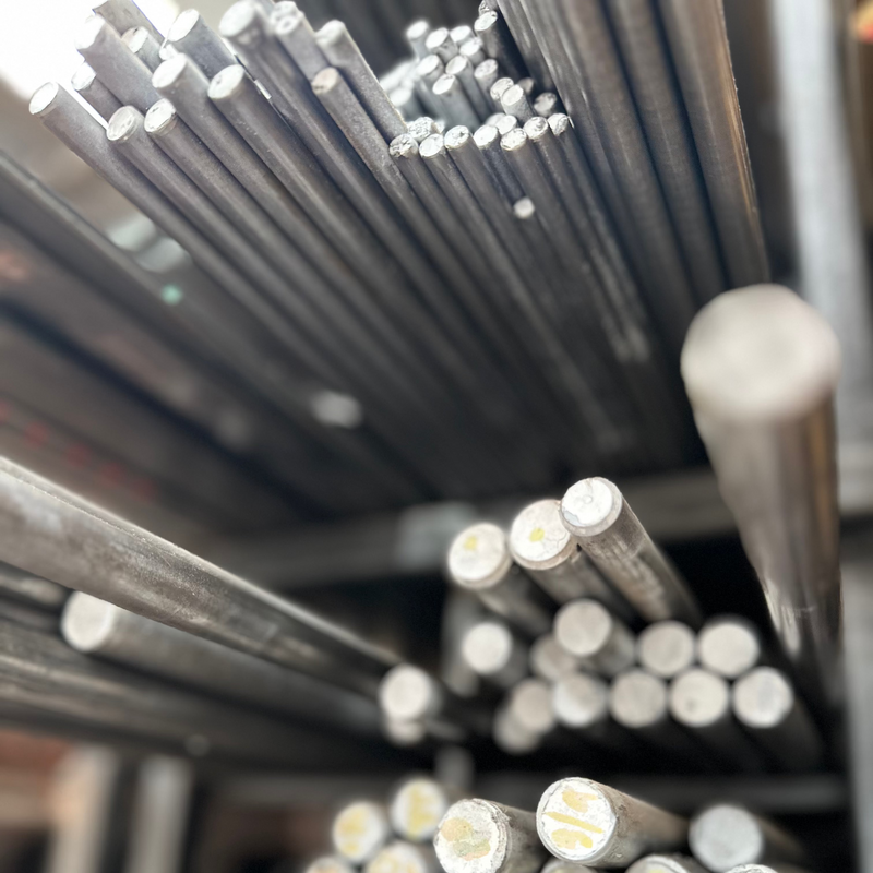 Fotografía de barras de acero inoxidable de distintas medidas en rack.