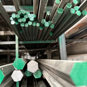 Perfiles hexagonales de acero, pintados de color verde acomodados en rack.