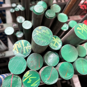 Barras de diámetros chicos pintados de verde en rack.