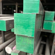 Fotografía de perfiles cuadrados de acero almacenados y pintados color verde.