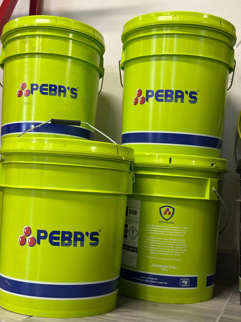 Fotografía de 4 cubetas verdes de soluble marca Pebas apiladas en 2 torres.